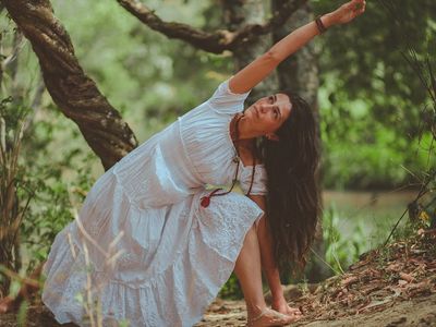 A person's focused expression during a balancing yoga posture.