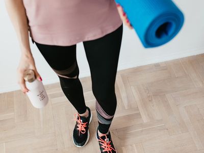 A yoga block and a water bottle on a wooden floor.