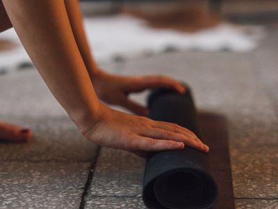 Close-up of hands in a meditative pose on a yoga mat.