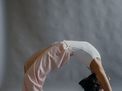 Silhouette of a person in a gentle stretching yoga pose.